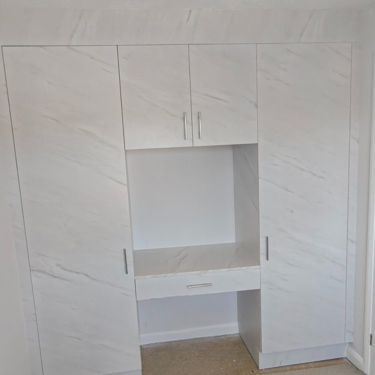 bedroom installation White wardrobe with a central desk space and three cabinet sections.