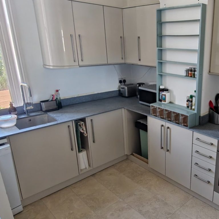 Replacement worktops Modern kitchen with light-coloured cabinets, countertop appliances, and a neatly organised layout.