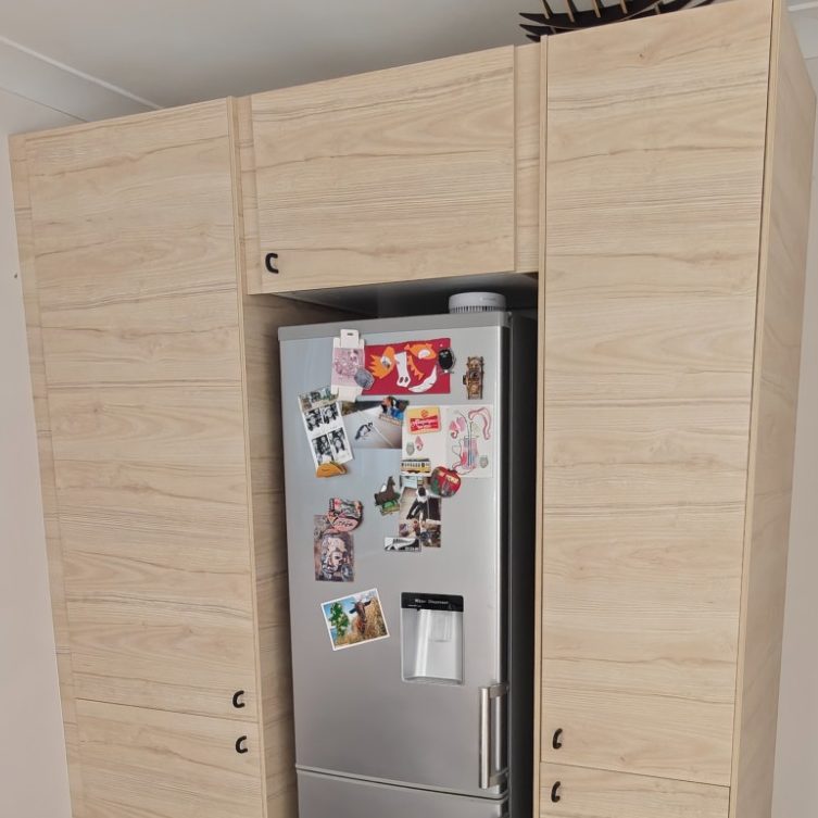 Fridge freezer surround Modern kitchen with a silver refrigerator and wooden cabinetry.