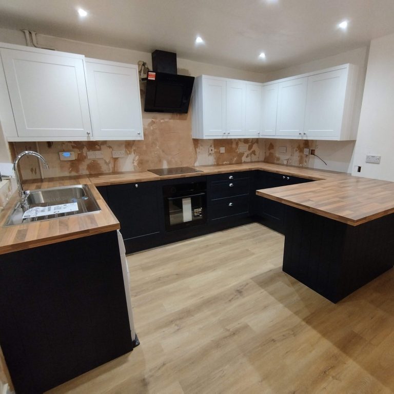New Wren kitchen Modern kitchen with wooden countertops, black cabinets, and a stainless steel sink.