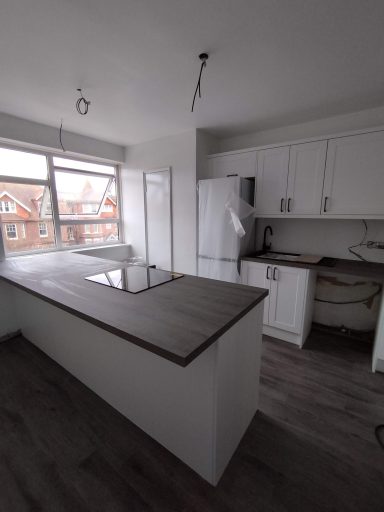 Modern kitchen featuring white cabinetry, a central island, and large windows.